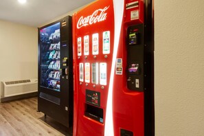 Dos máquinas expendedoras, una roja y otra negra, con diversas opciones de bebidas.