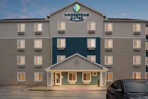 Un hotel de varios pisos con un letrero que dice 'Woodspring Suites'.