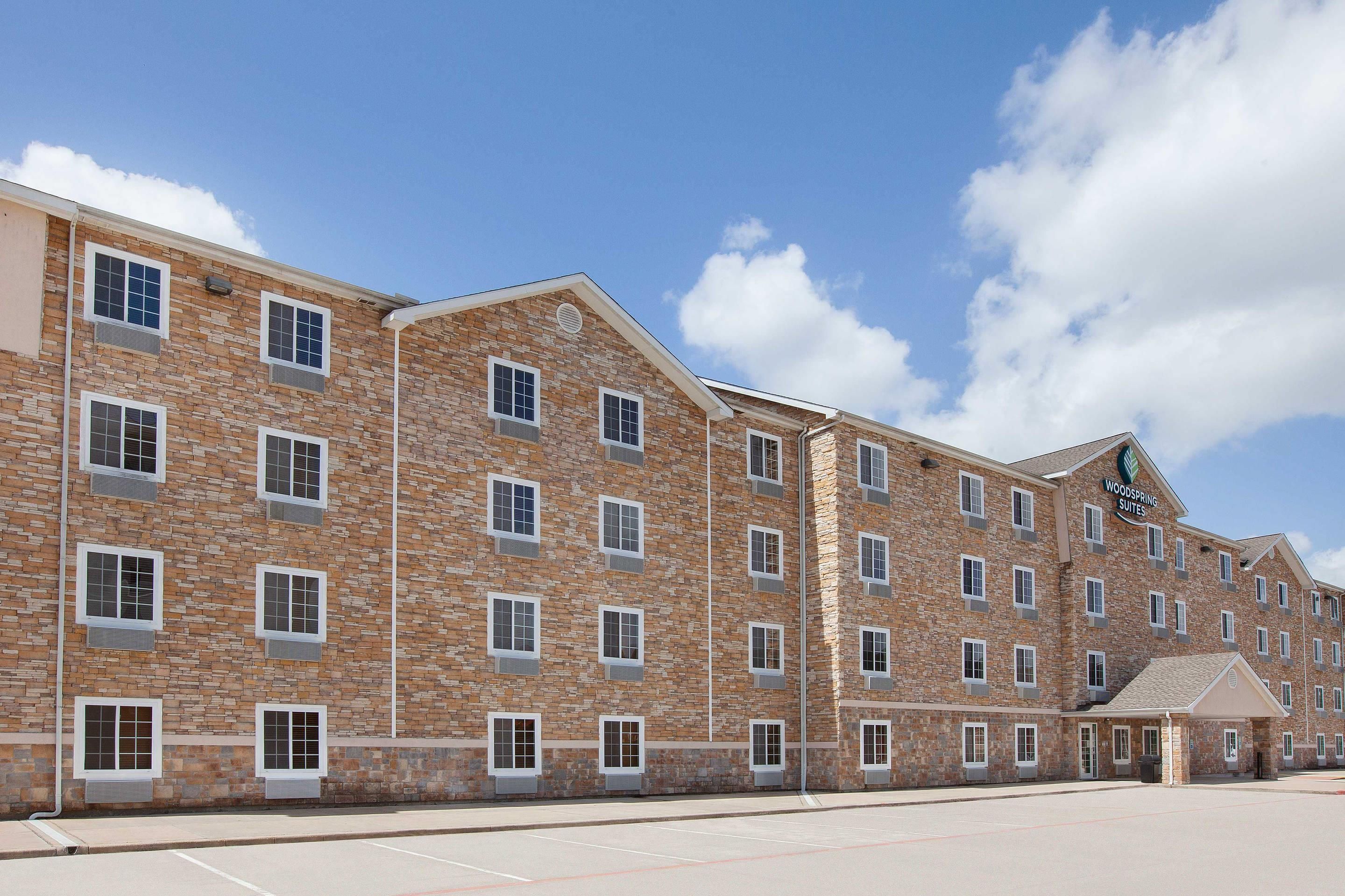 A multi-story hotel with a stone facade, multiple windows, and a clear sky.