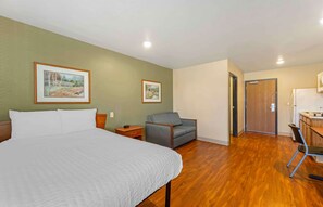 Relax in a spacious room with a large bed, framed artwork, and a convenient workspace.