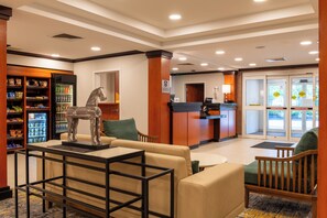 A lobby with a reception desk, seating area, and vending machines. - Fairfield Inn & Suites by Marriott Hooksett (Hooksett)