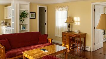 Grand Suite | Living room | 34-inch flat-screen TV with digital channels, TV, books