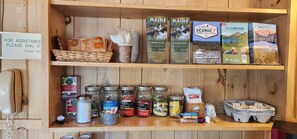 A shelf with travel guides, snacks, and a phone for assistance.