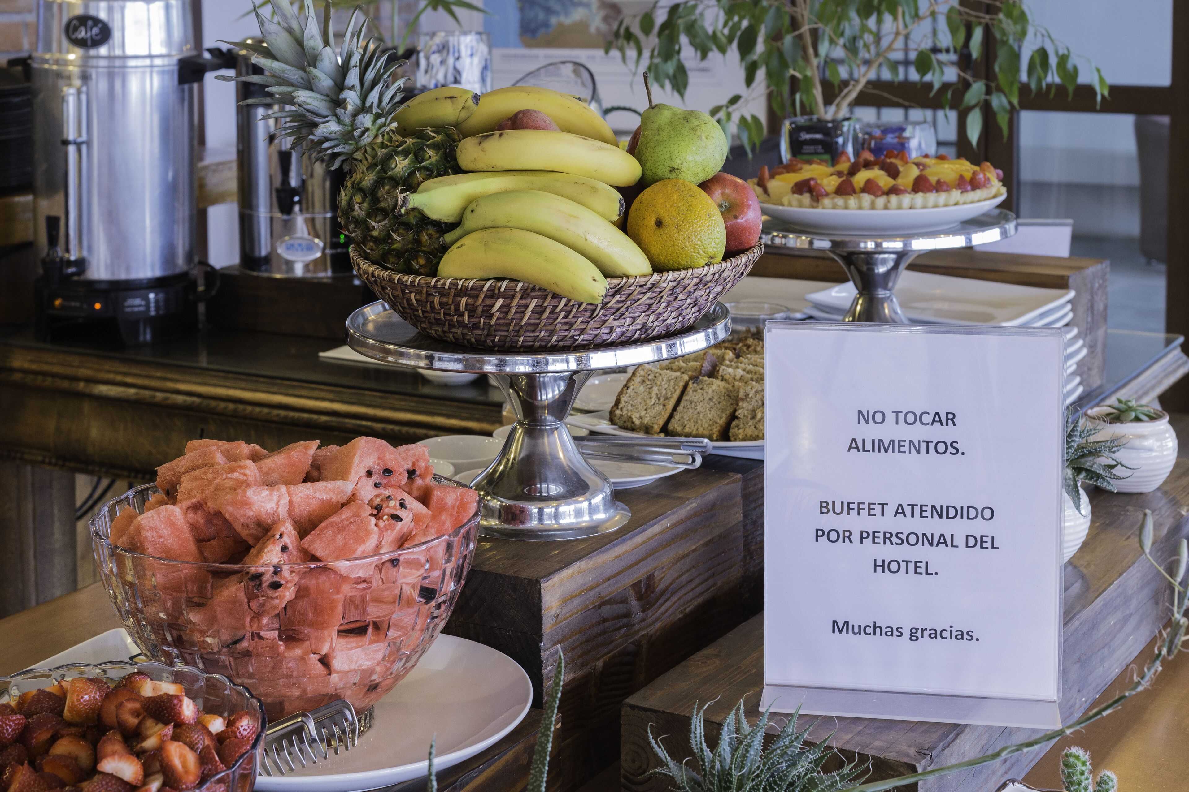 A buffet with various fruits and a sign in Spanish.