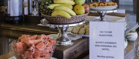 A buffet with various fruits and a sign in Spanish.