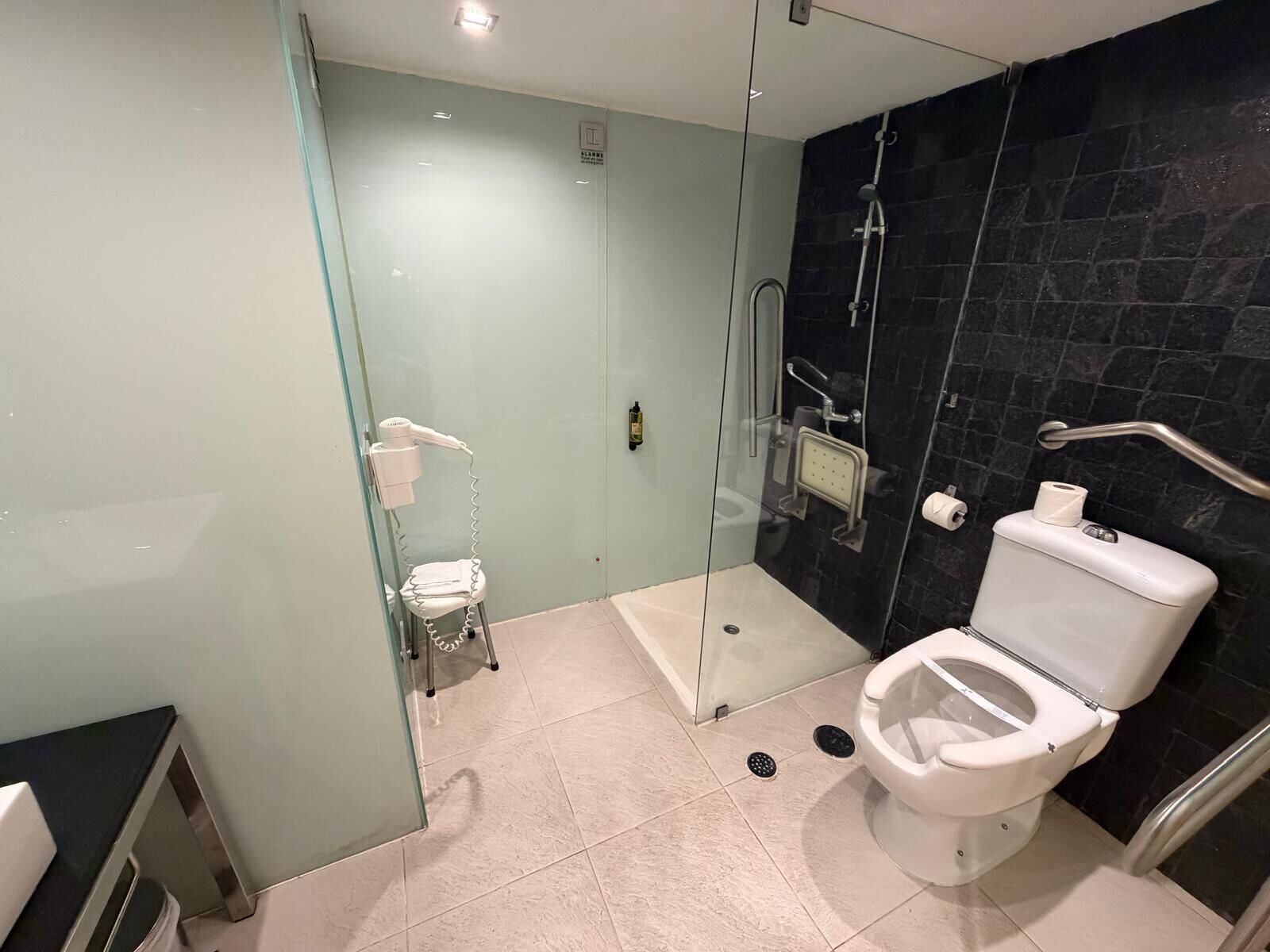 Une salle de bain moderne avec une douche à parois de verre, des toilettes blanches et une cloison en verre.