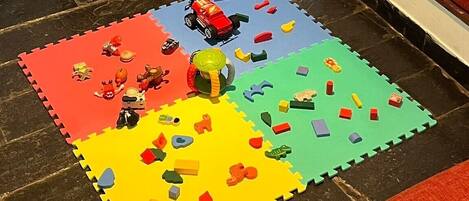 Un tapete colorido con varios juguetes y piezas de puzzle.