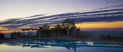 Una piscina al aire libre de temporada, tumbonas