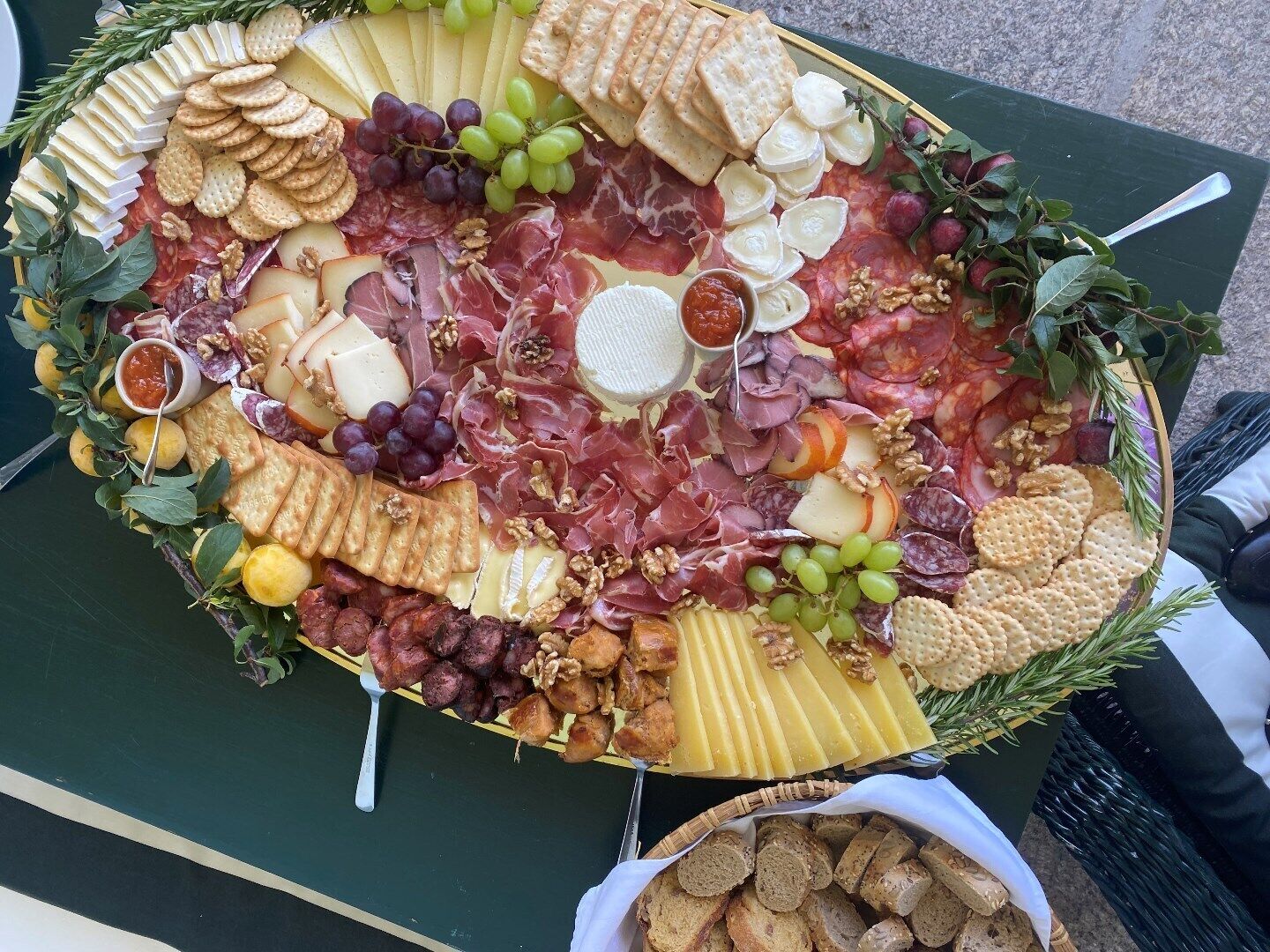 A charcuterie board with various cheeses, meats, and crackers.