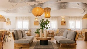A spacious living room with two sofas, a round coffee table, and a large plant. - Camarao (Mafra)