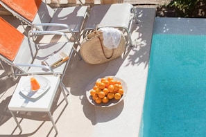 Una piscina al aire libre, sombrillas, tumbonas