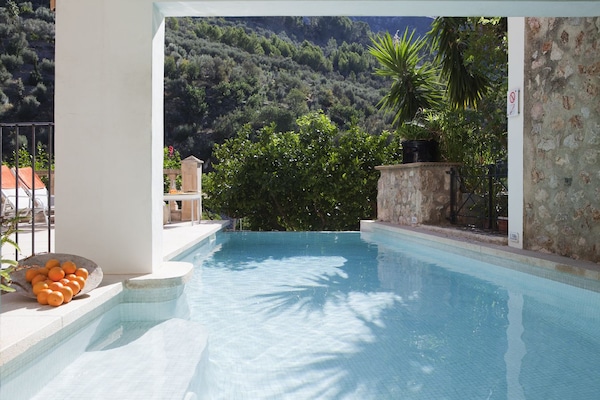 Una piscina al aire libre, sombrillas, sillones reclinables de piscina