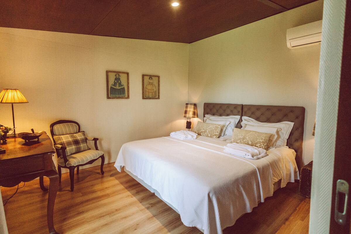 Une chambre à coucher comprenant un lit, une chaise, un bureau et deux lampes fixées au mur.