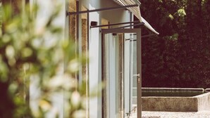 A modern building with a sloped roof, large windows, and a stone pathway leading to a door. - Quinta Do Monteverde (Viana do Castelo)
