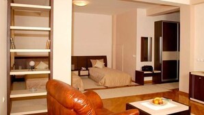 A modern hotel room with a bed, a desk, a chair, and a wardrobe. - Premier Hotel (Skopje)