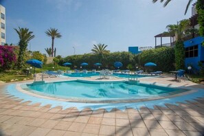 Una piscina al aire libre, sombrillas