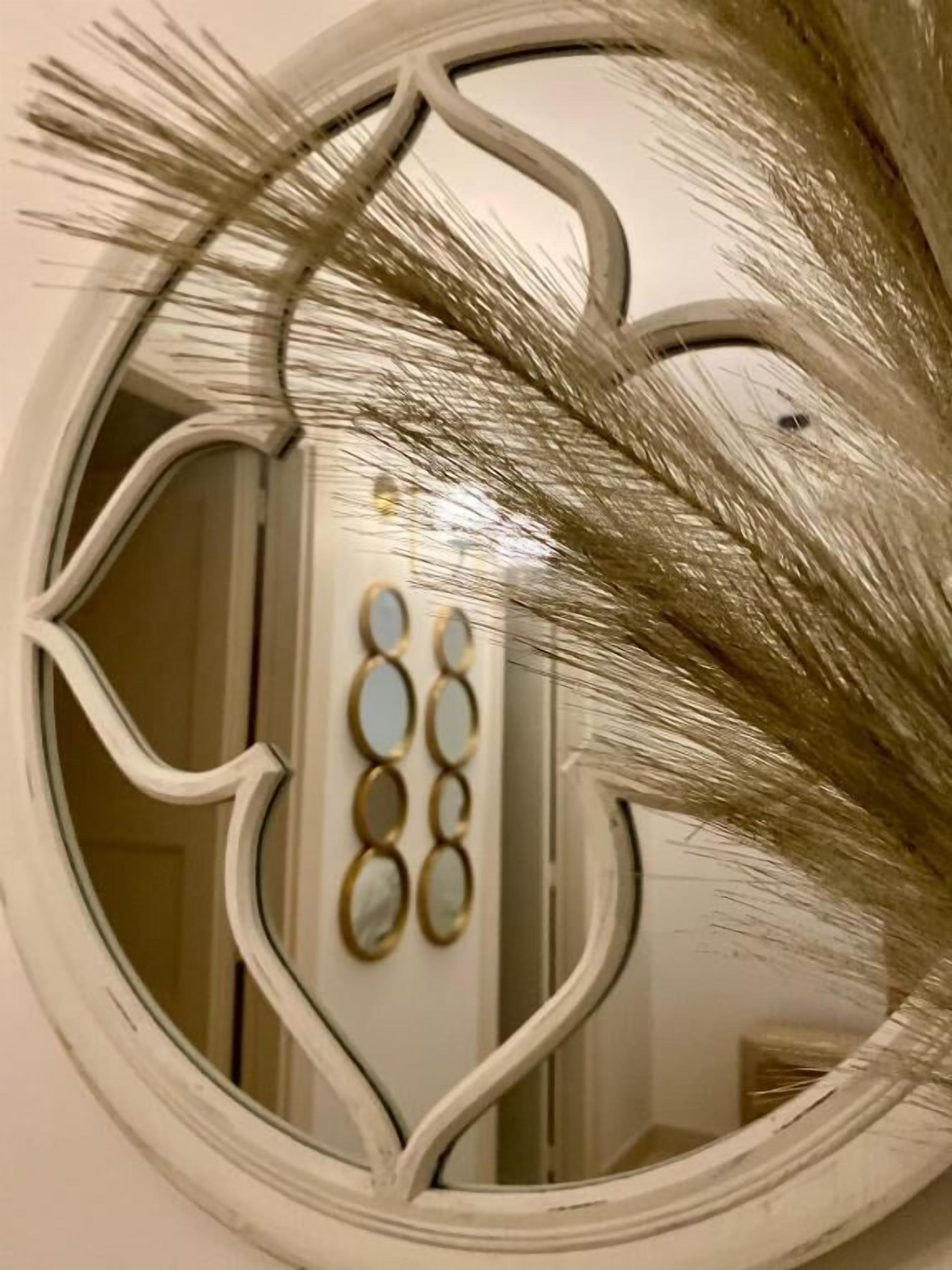 Un miroir rond doté d’un cadre orné.
