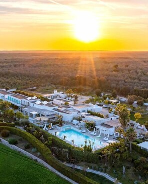 Un resort con varias edificaciones, piscina y zonas ajardinadas.