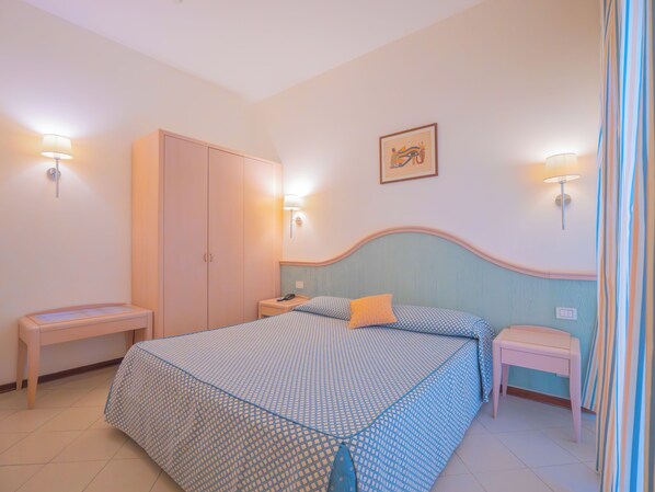 A bedroom with a bed, nightstands, a wardrobe, and wall-mounted lights. - Hotel Splendid (Diano Marina)