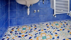 Un baño con lavamanos, espejo y perchero para toallas.