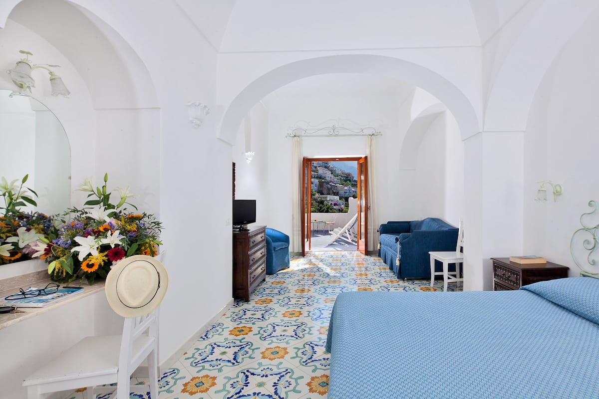 Vierpersoonskamer | Een minibar, een kluis op de kamer, een bureau, gratis wifi