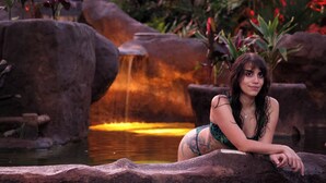 A person sitting on a rock by a waterfall in a natural setting. - Volcano Lodge Hotel & Thermal Experience (La Fortuna)