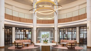 A spacious lobby with a central round table, seating arrangements, and a modern chandelier. - Wyndham Grand Algarve Quinta do Lago (Loulé)