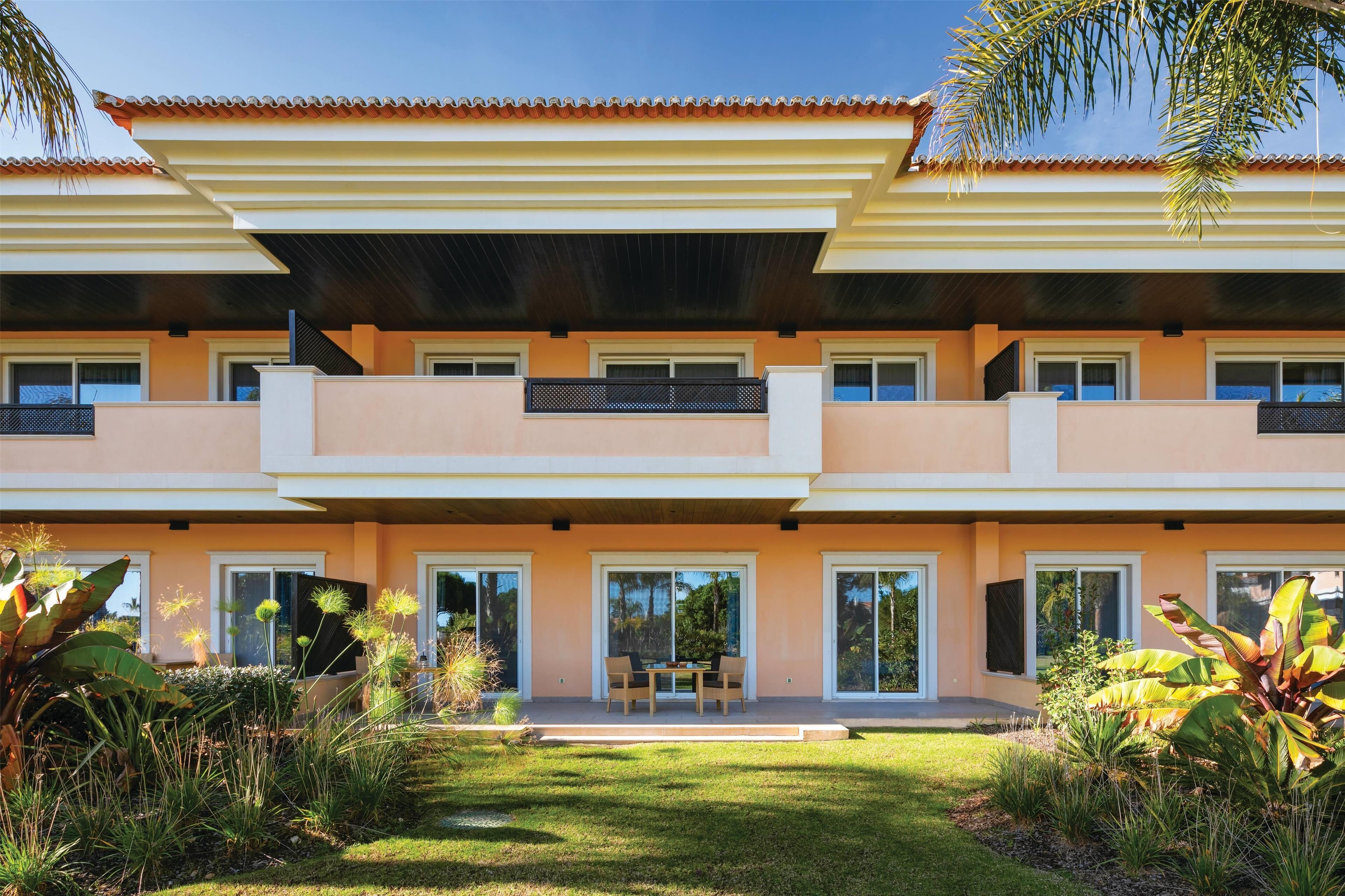 A two-story house with a flat roof, large windows, and a well-maintained garden.