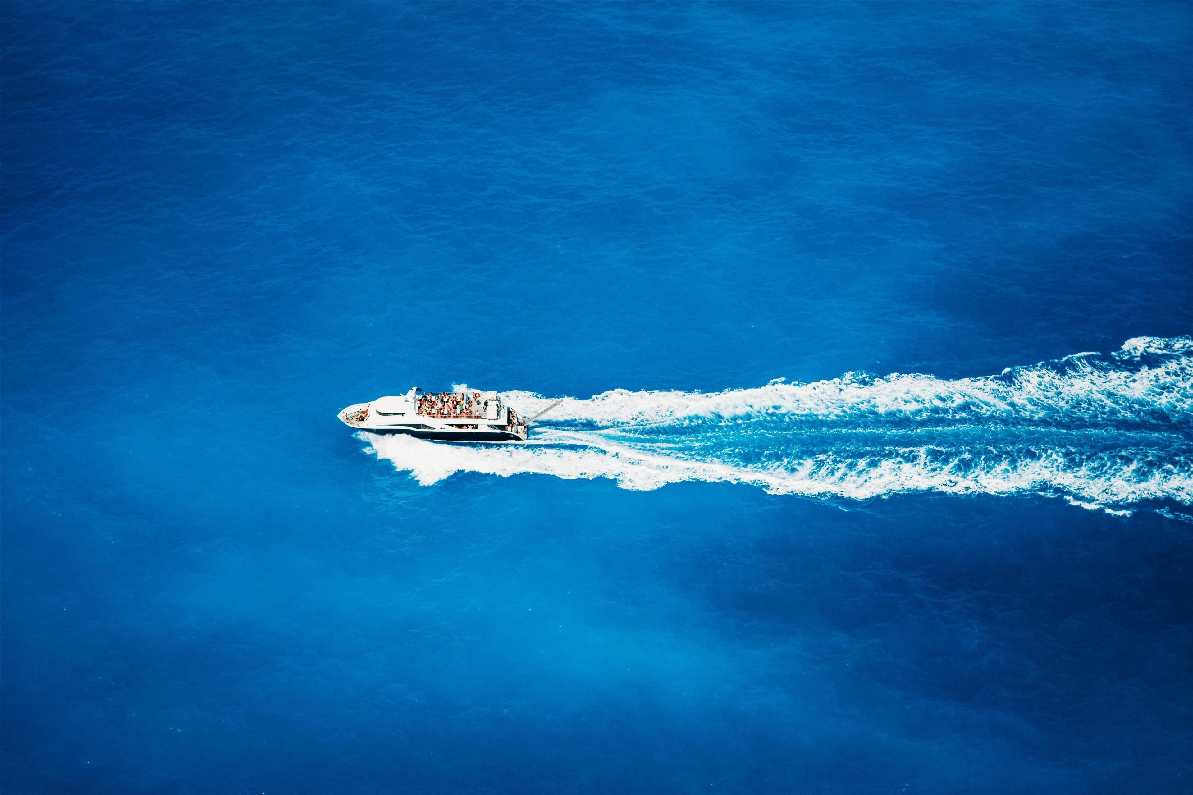 A boat with passengers moving through a body of water.