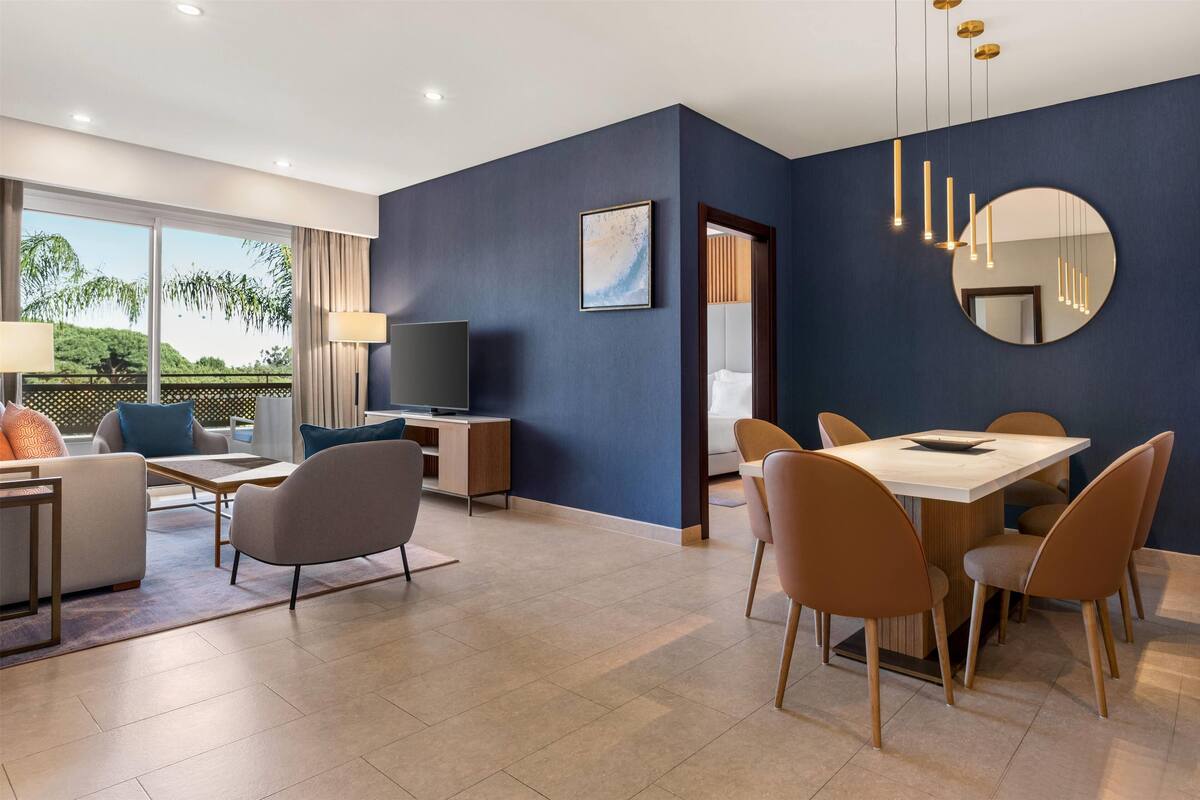 A modern living room with a TV, sofa, and dining area.