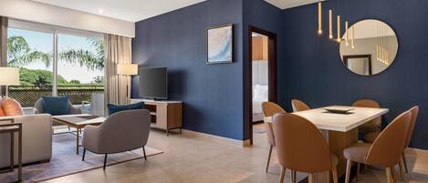 A modern living room with a TV, sofa, and dining area.