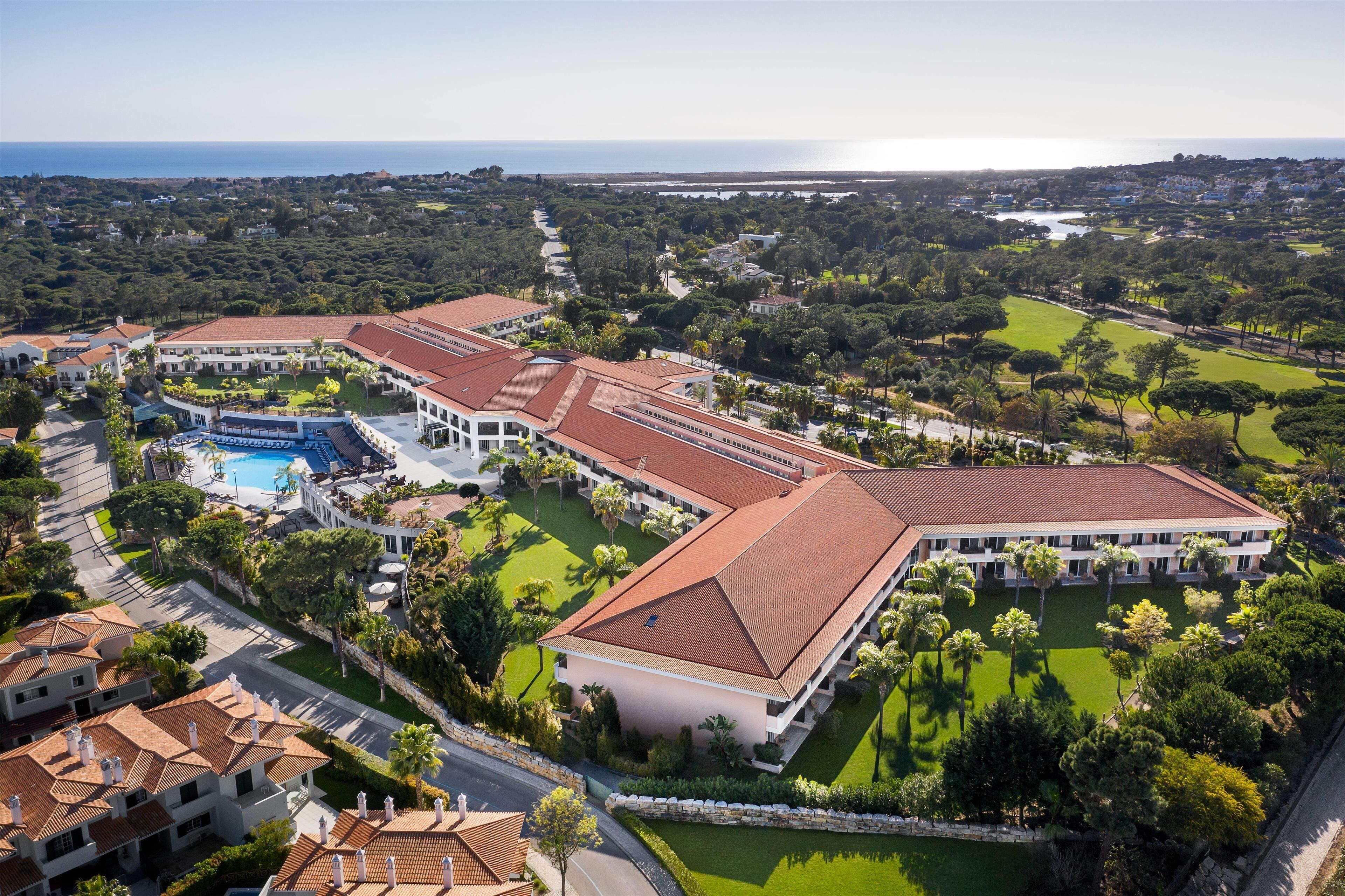 Un gran complejo turístico con varias construcciones, piscina y jardines bien cuidados.