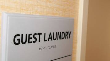 A sign reading "GUEST LAUNDRY" on a wall.
