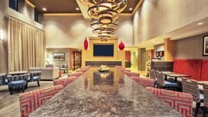 A spacious conference room with a long table, multiple chairs, and a modern chandelier.