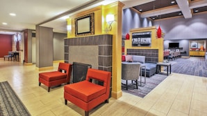 A hotel lobby with seating areas, a reception desk, and a bar/lounge area.