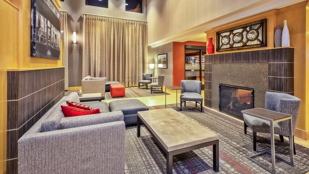 A spacious lounge area with a sofa set, a coffee table, and a fireplace.