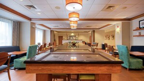 A hotel lobby with a central bar, seating areas, and a reception desk. - Hampton Inn Wilmington - University Area/Smith Creek Station (Wilmington)