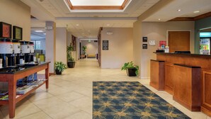 A hotel lobby with a reception desk, a coffee station, and a reception area. - Hampton Inn Wilmington - University Area/Smith Creek Station (Wilmington)