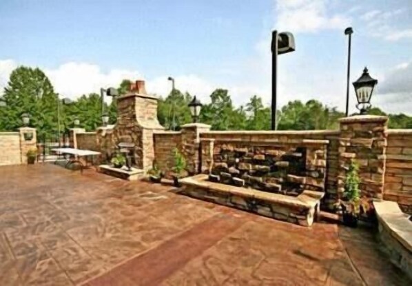 A patio area with stone walls, a fire pit, and outdoor furniture.
