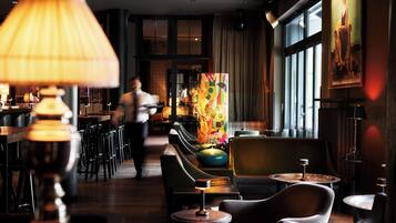 A restaurant with a bar area, seating, and a large window.