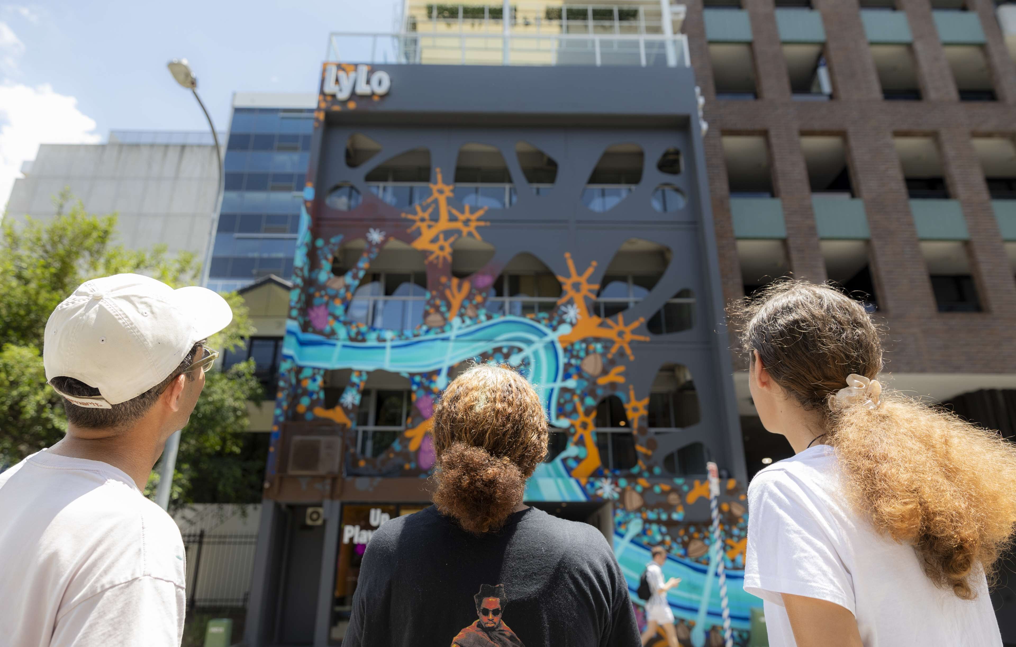 Un edificio con un mural colorido y un cartel que dice "lyLo".