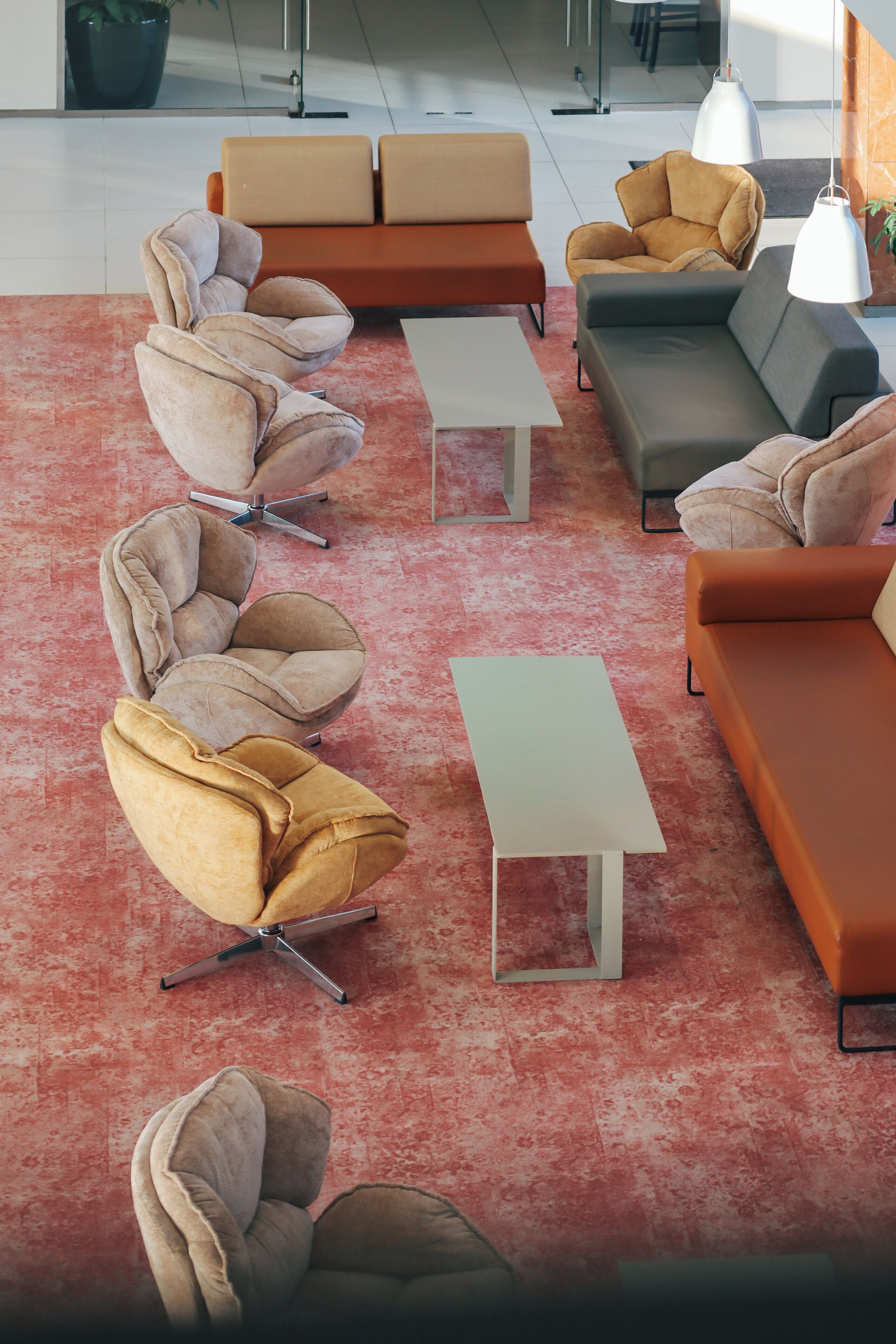 Un área de estar moderna con sofás, sillones y una mesa de centro.