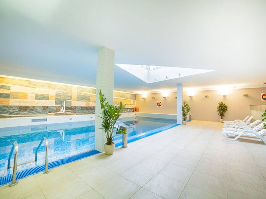 Una piscina techada, sillones reclinables de piscina