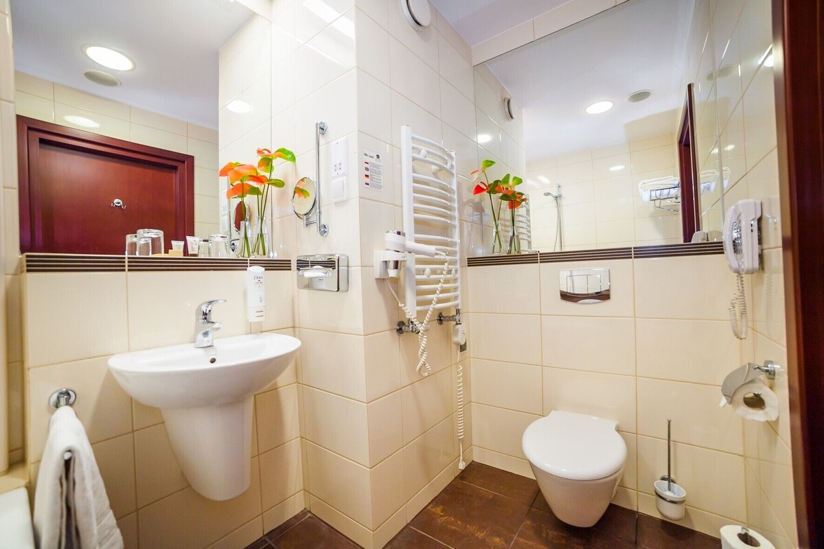A bathroom with a sink, toilet, and shower.