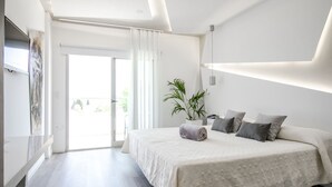 Ein modernes Schlafzimmer mit einem großen Bett, einer Zimmerpflanze und einer Schiebetür zu einem Außenbereich.