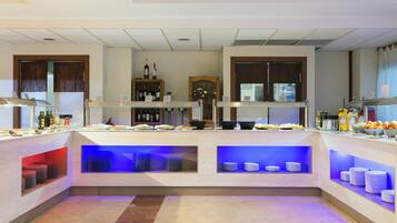 Un vestíbulo de hotel con mostrador de recepción, exhibición de vinos y zona de bufé.