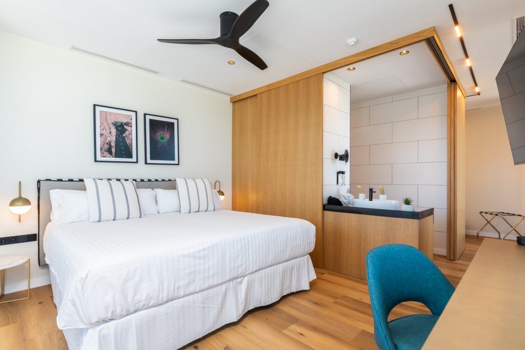 Une chambre à coucher moderne avec un grand lit, un bureau et une chaise.