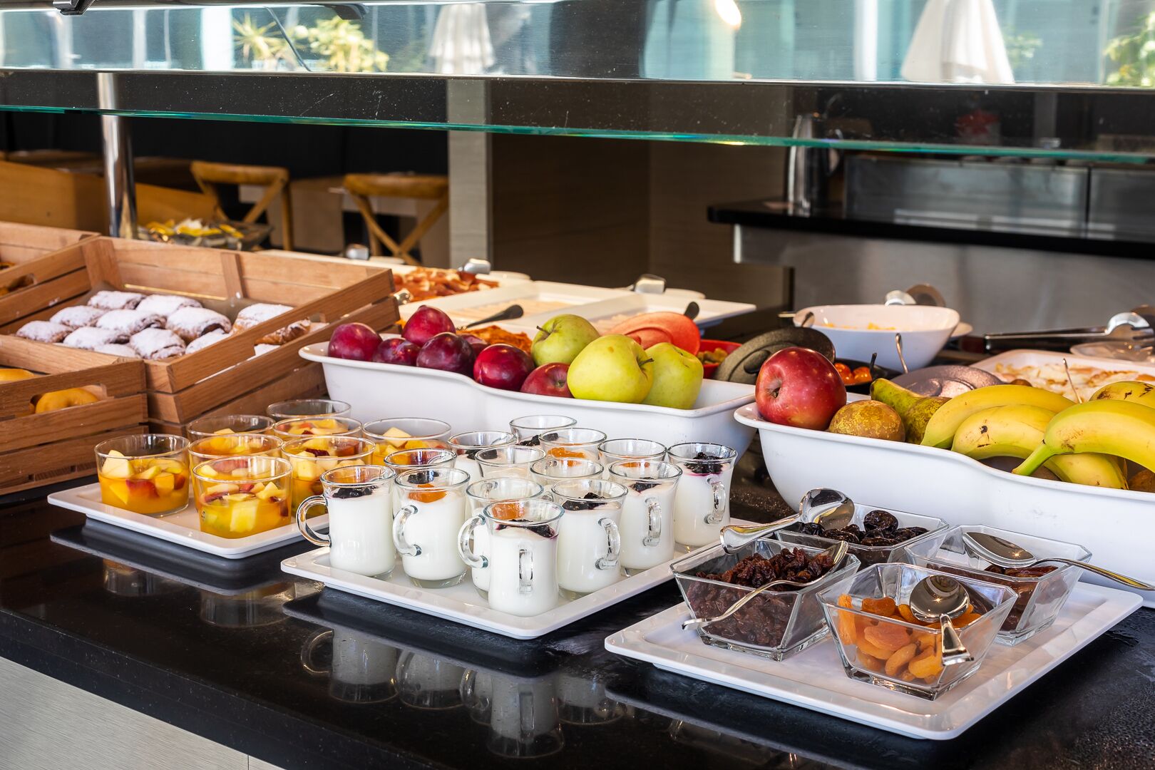 A buffet with various fruits, dairy products, and desserts.