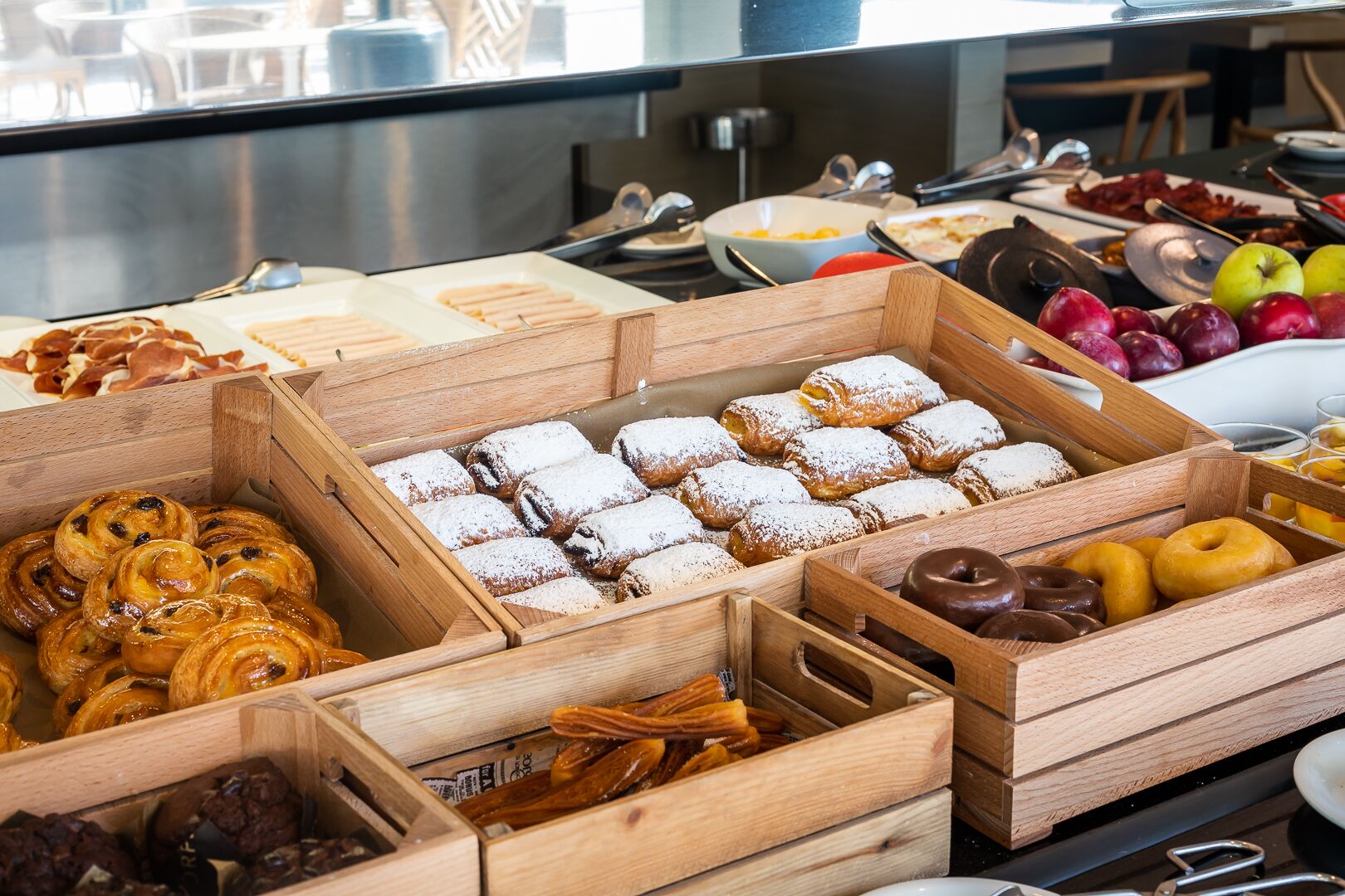 A buffet with various pastries and fruits.