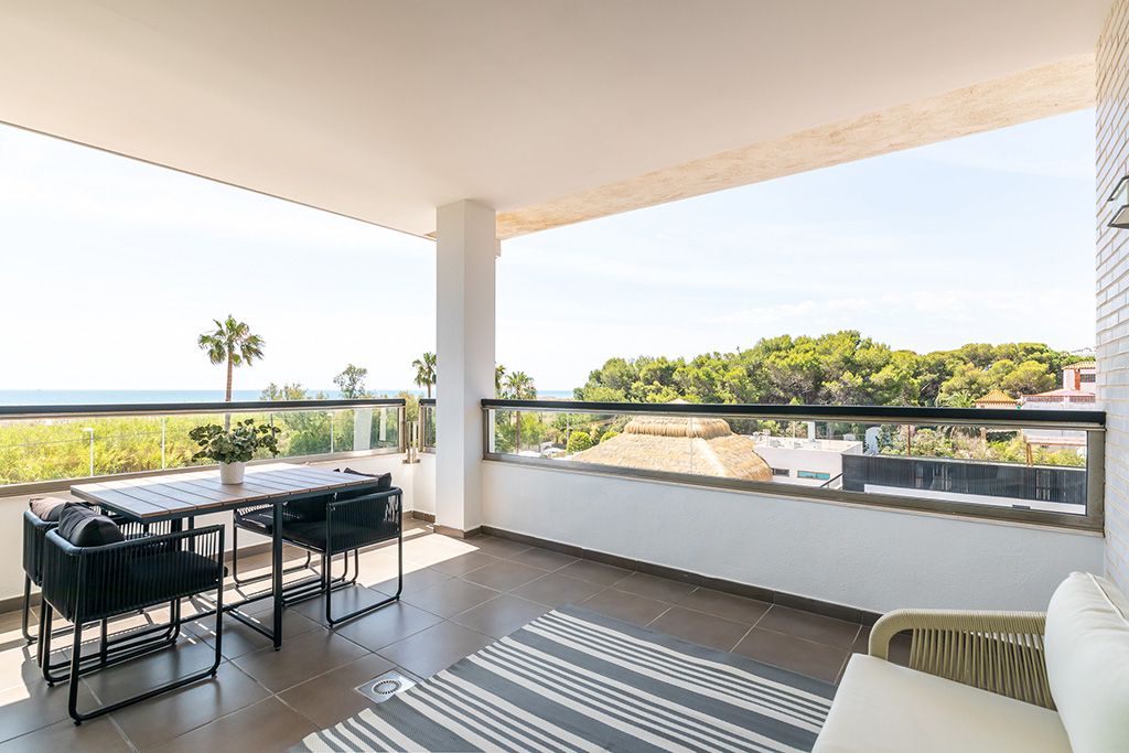A balcony with a view of a green landscape and a building in the distance.